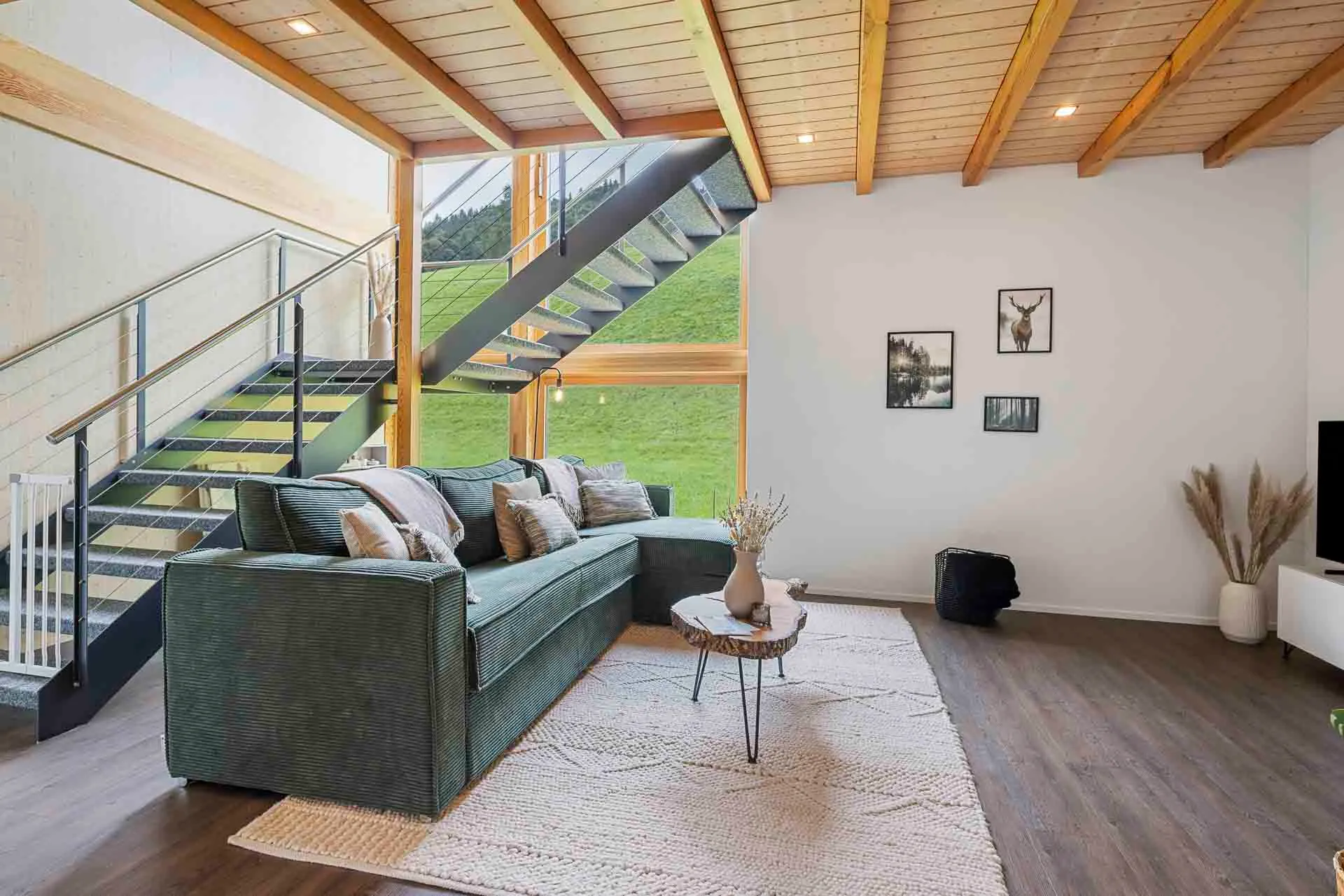 Sofa corner in front of the window wall facing the meadow
