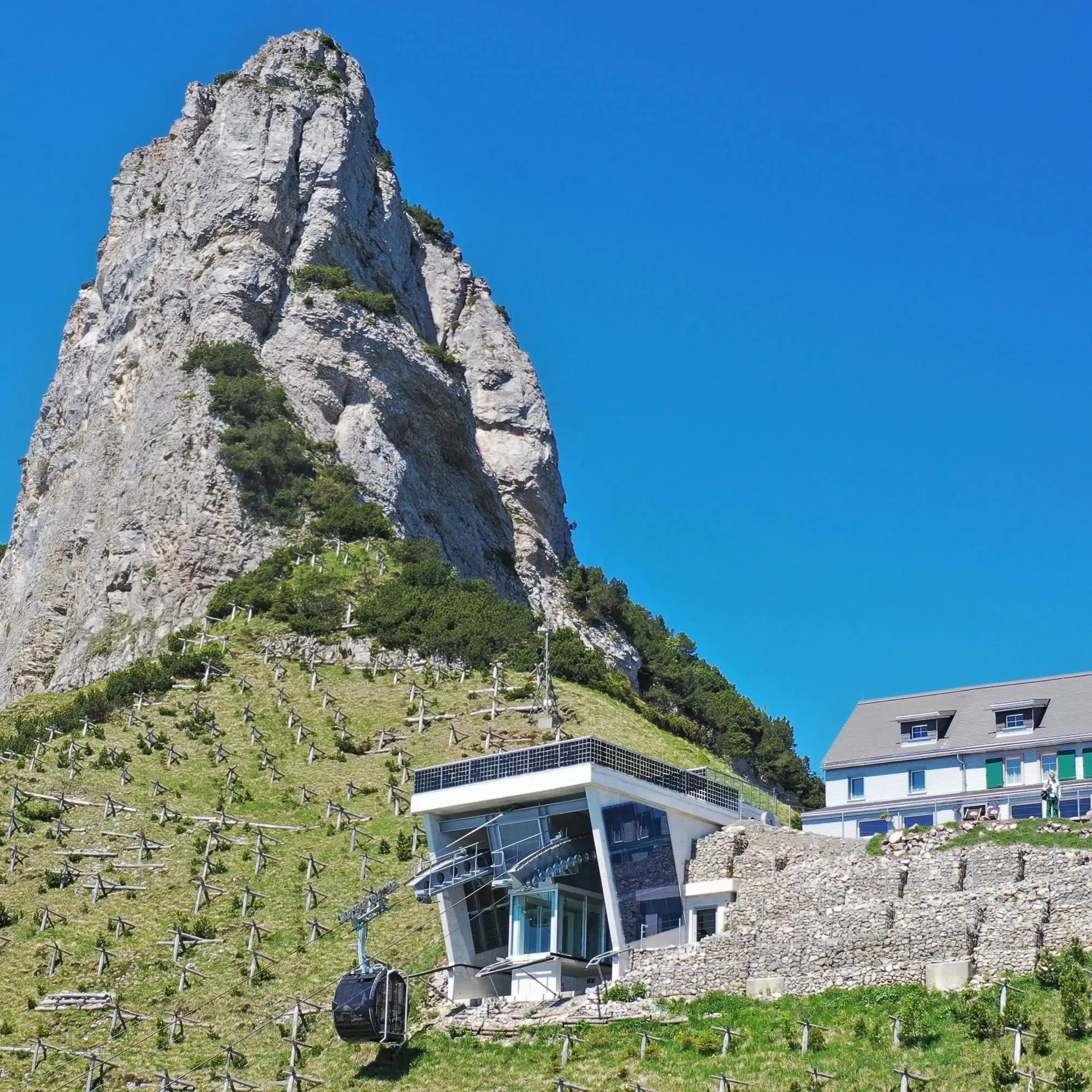 Die Bergstation der Staubernbahn mit Solarpaneelen auf dem Dach, im Hintergrund der markante Felsturm